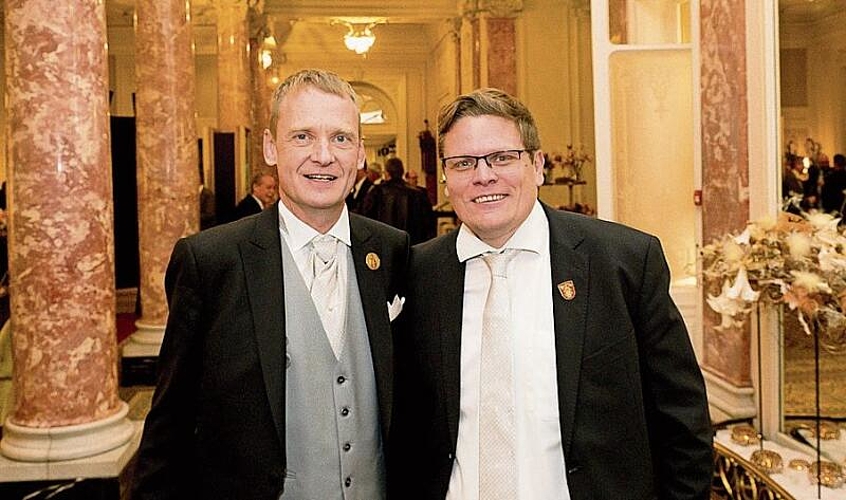 Zunftratsmitglieder Adrian Krummenacher (l.) und René Gmür. Adrian übergibt die Zunftkasse an seinen Nachfolger mit einem Augenzwinkern, dass er sie umsichtig weiterführe.