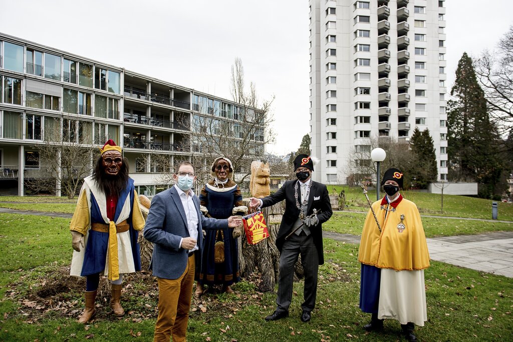 Dani Medici, Zunftmeister Zunft zu Safran, überreicht mit Bruder Fritschi (l.), Fritschene und Weibel Richi Hess (r.) Joel Früh, Betriebsleiter Betagtenzentrum Viva Luzern Eichhof, ein Zunftsäckli.