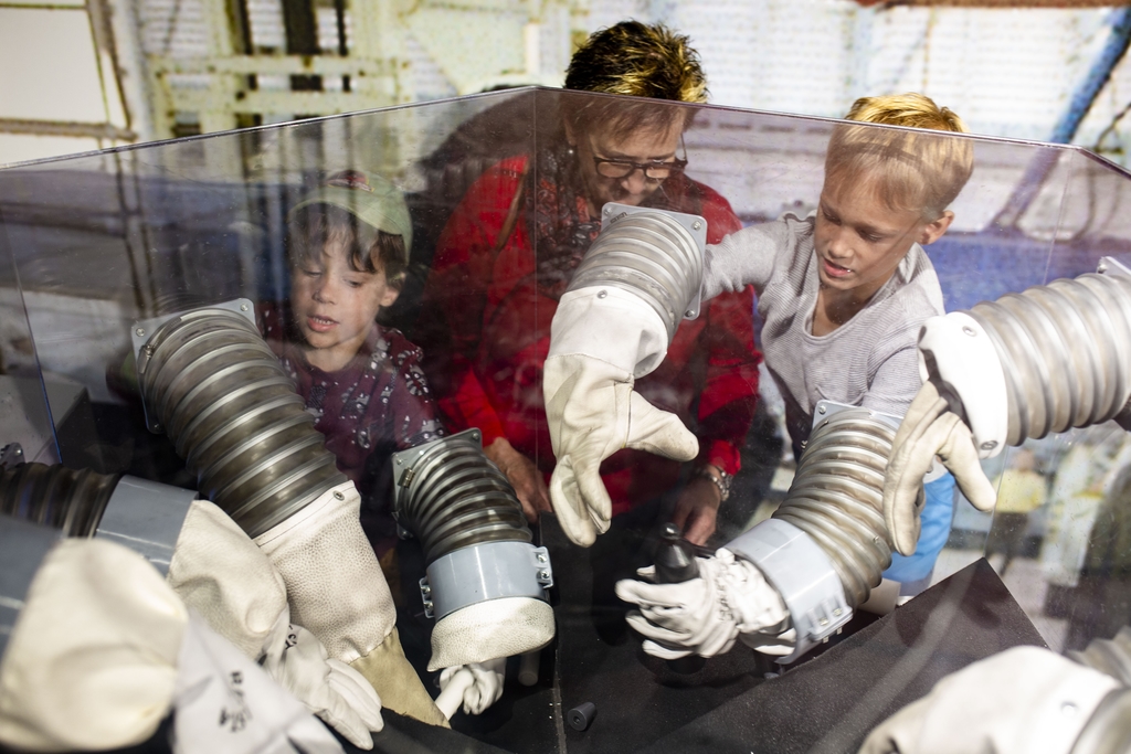 Mit klobigen Astronautenhandschuhen ausgestattet, trainierten (von links) Morris, Heidi und Marvin Stirnemann das Basteln im Weltraum.